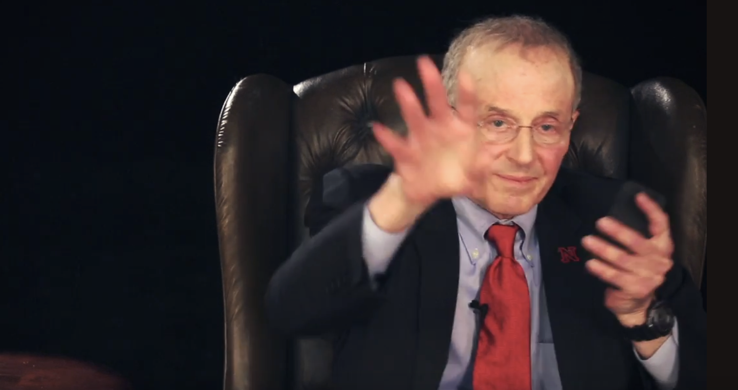 Perlman looking at his cell phone and waving at us to go away