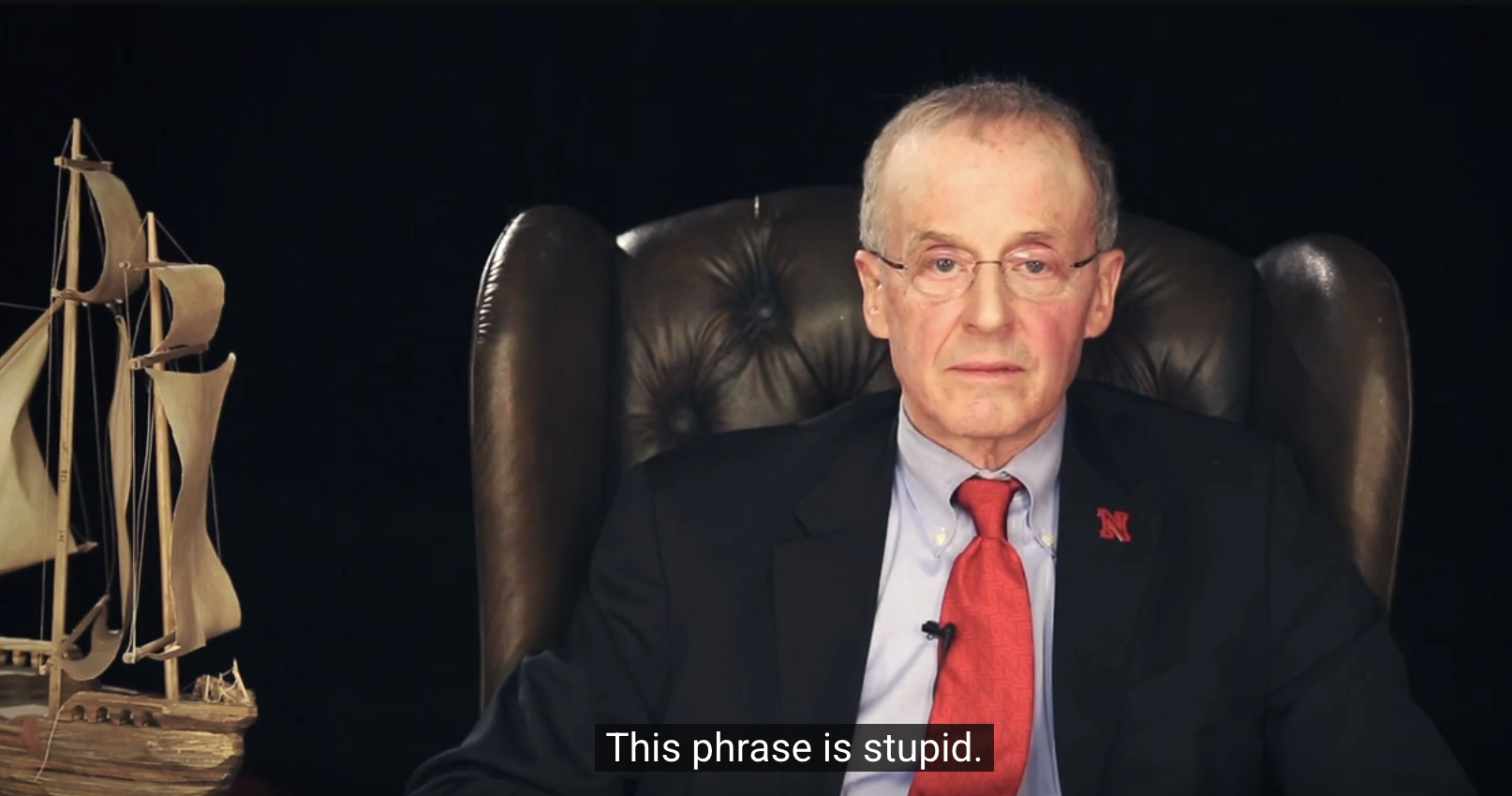 Perlman sitting in a leather chair, the captioned text says 'this phrase is stupid' underneath him