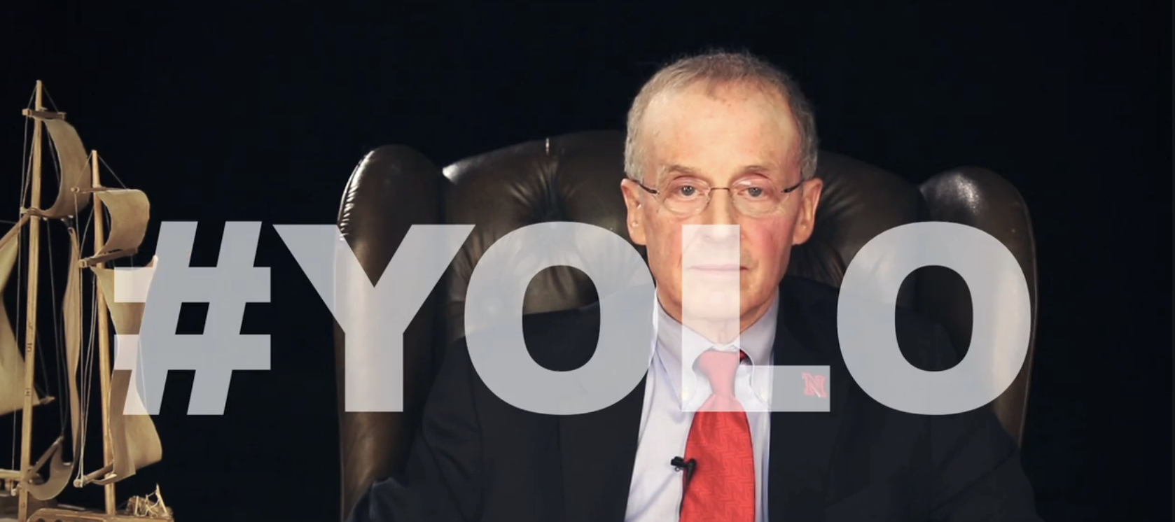 Perlman with a straight face with the hashtag yolo in giant letters superimposed over him